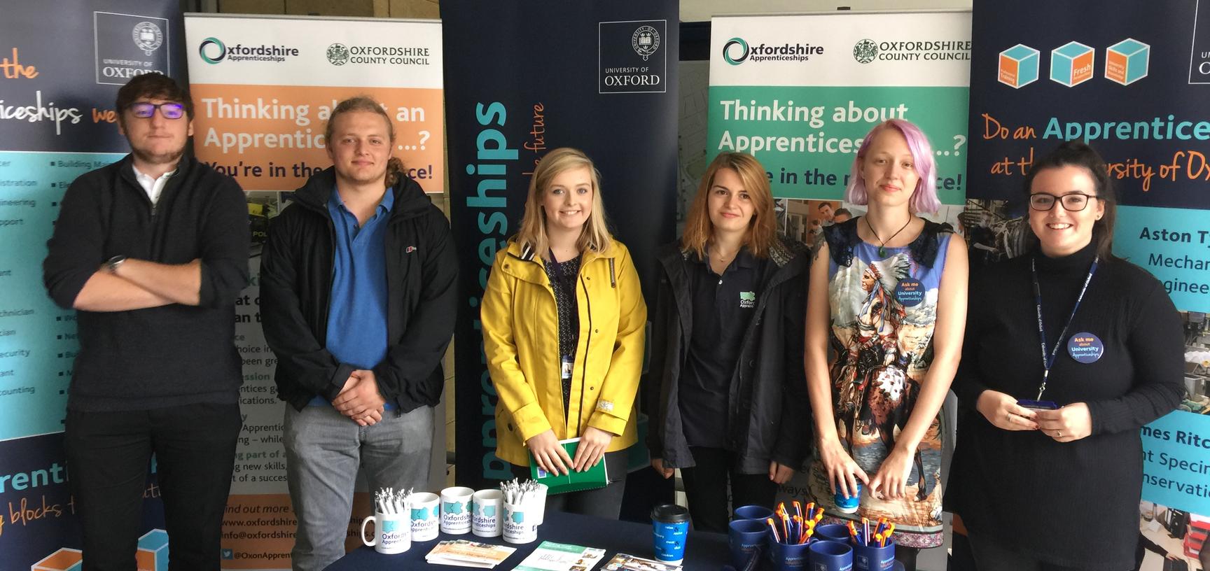 A mixed group of University of Oxford Apprentices at a careers fair talking about Oxfordshire Apprenticeships